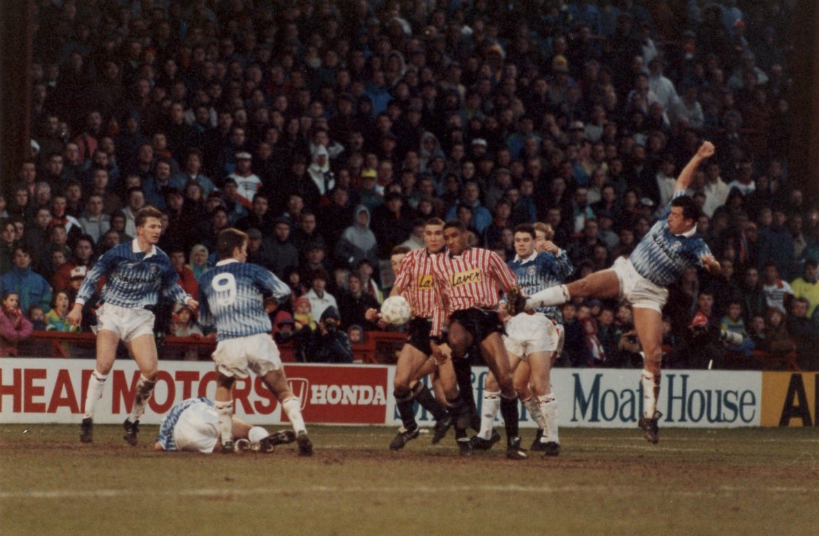 1990-91 Season DONE/Matches/M3941 Sheffield United v Luton Town/Photos/Anxious looks all around as P868 Darron McDonough jumps in for the ball.jpg