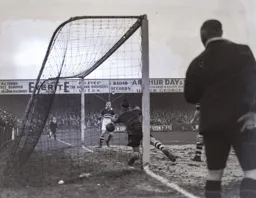 The Cobblers goalkeeper dives in vain to prevent the third goal scored by Roberts