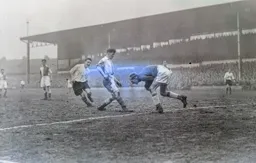 Charlie Watkins closes in as Reg Elvy gathers the ball