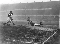 Les Major smothers the ball. Bert Mitchell and Gordon Turner are on hand in case of an error