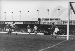 Gordon Turner miskicks the ball but it runs loose to Jimmy Adam who slams it into the net for Town`s third goal