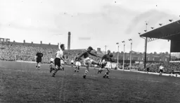 The ball is cleared before Roy Davies can intervene