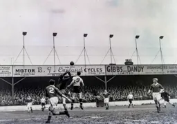 The keeper punches the ball away from Bob Morton