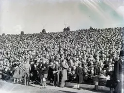 Some youngsters spill onto the cinder track as 27,148 pack in to Kenilworth Road