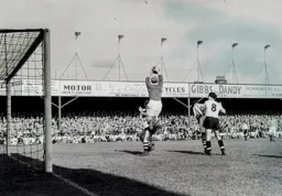 Jim Sanders safely catches the ball and a defender makes sure Gordon Turner cannot get close