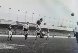 Alf Sherwood heads the ball away from Mike Cullen