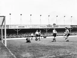 Bernard Streten lays on the ball with added protection from Wally Shanks and Syd Owen