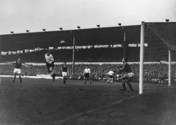 Mick Cullen directs a header at goal but Nigel Sims will make the save