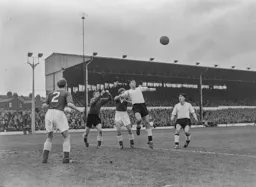 Jimmy O`Neill punches the ball away from the head of Bob Morton
