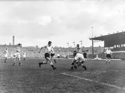 George Cummins chase for the ball is in vain as Jim Sanders has it in his grasp