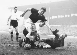 Bernard Streten dives at the feet of Terry Medwin