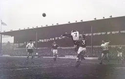 Reg Matthews punches the ball clear under pressure from Brian Whitby