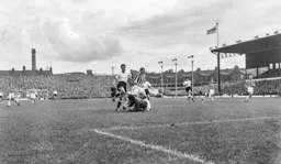 Clive Jackman dives in bravely at the feet of Billy Bingham