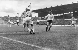 Stuart Williams looks to clear the ball for Albion as John Groves closes in