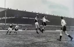 Allan Brown and Brian Miller battle for a high ball. Billy Bingham is ready to pounce on any