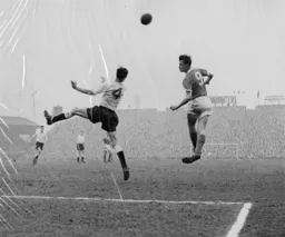 Ray Charnley sends a header towards goal despite the challenge of John Groves