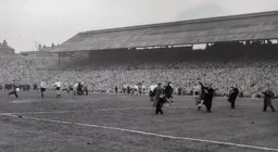 Ron Baynham is surrounded by photographers at the final whistle