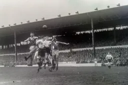 Dave Pacey goes up for a header between two Blackpool defenders