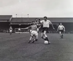 Mike Tracey is tackled by Liverpool's Gordon Milne