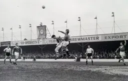 The ball is cleared watched by Roland Legate