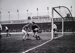Ron Baynham looks to clear the ball