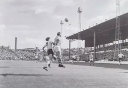 A defender heads the ball away from Tommy McKechnie