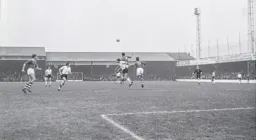 Tommy McKechnie loses out to Gordon Parr as he heads the ball clear