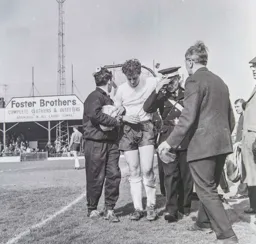An injured Graham Caleb is helped from the field