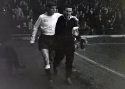 An injured Alan Slough is helped from the field by trainer Charlie Watkins