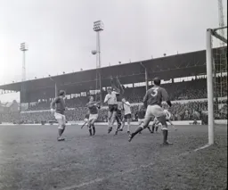 John Roberts comes out of his goal to catch the ball under pressure from Terry Branston