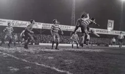 Bruce Rioch loses out as the ball is headed clear