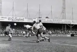 Ian Buxton`s close range header is covered by MIke Rose