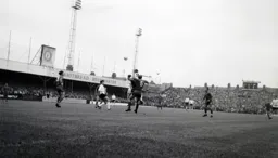 Laurie Sheffield heads the ball down towards John Ryan