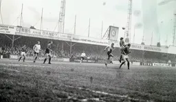 Rovers head the ball away from Laurie Sheffield as the rain pours down