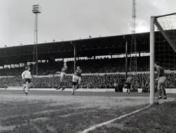 Brian Lewis watches as a defender appears to balance the ball on his head