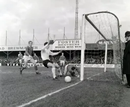 Under the eye of the law Bob Wesson pushes the ball away from Bruce Rioch