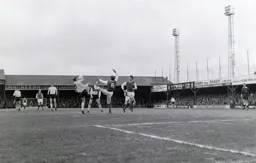 Brian Lewis and Norman Gall go for the ball with raised boots