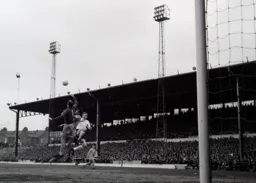 Brian Lewis jumps in as Mike Walker punches the ball away