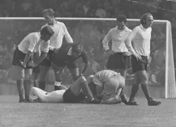 Concerned Luton players look on as a colleague is treated