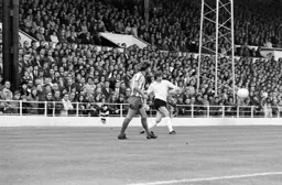 John Ryan crosses in front of the Main Stand