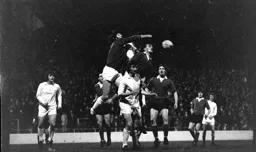 John Moore watches on a keeper punches ball off Viv Busby’s head