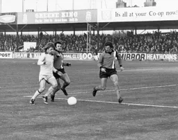 Jimmy Husband, on his debut, goes for the ball watched by Bobby Thomson