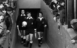 Referee Peter Reeves leads out his team