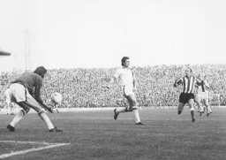 Keith Barber safely gathers the ball watched by Bobby Thomson