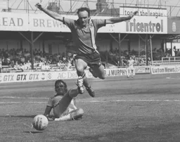 John Aston hurdles Blades defender Colin Franks