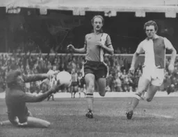 Keith Barber holds on the ball watched by John Faulkner