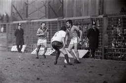 Wayne Turner watches on as David Moss takes on a defender