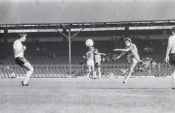 Raddy Antic strikes the ball towards goal while Kirk Stephens chats to one of the Bolton players