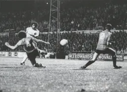 Ricky Hill attempts a shot against the defensive Welshmen