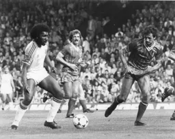 Ricky Hill invites Mark Lawrenson to try and take the ball away